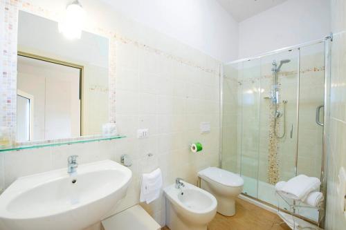 y baño con lavabo, aseo y ducha. en Hotel Maremma Sul Mare, en Montalto di Castro