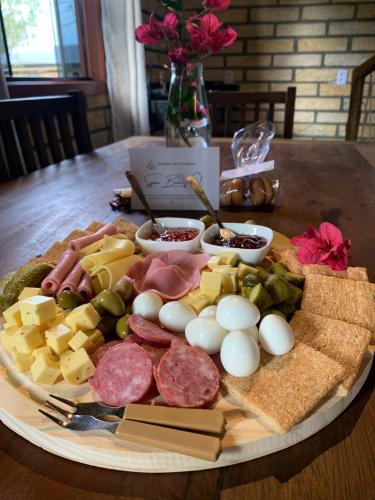 a plate of food with meats and cheese on a table at Pousada Equilíbrio dos Canyons in Praia Grande