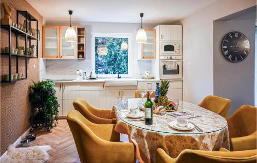 a kitchen with a table and chairs and a clock at Lovely Apartment In Stezyca With Sauna in Stężyca