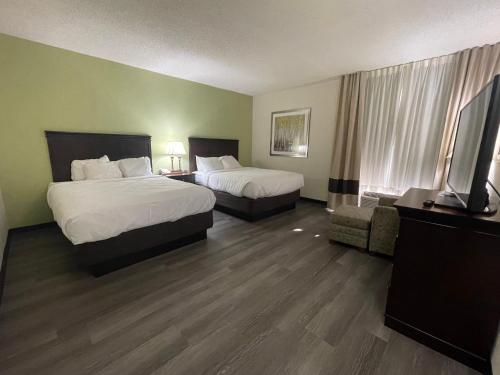 a hotel room with two beds and a flat screen tv at Comfort Inn Pinehurst - Southern Pines in Pinehurst