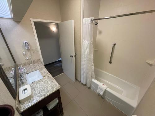 a bathroom with a tub and a sink and a shower at Comfort Inn Pinehurst - Southern Pines in Pinehurst