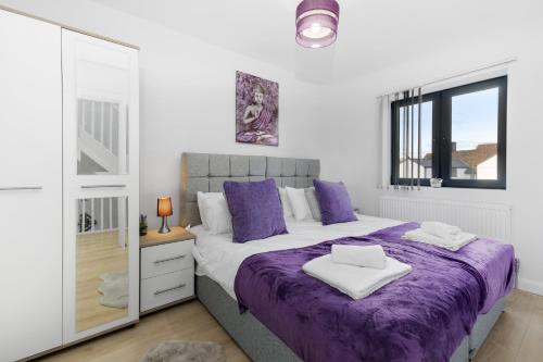 1 dormitorio con cama morada y espejo en Modern 4 Bedroom House With Parking in Farnham Royal, Slough By Ferndale en Slough