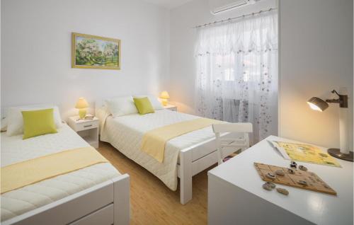 a white bedroom with two beds and a table at Nice Apartment In Nedescina With Wifi in Nedeščina