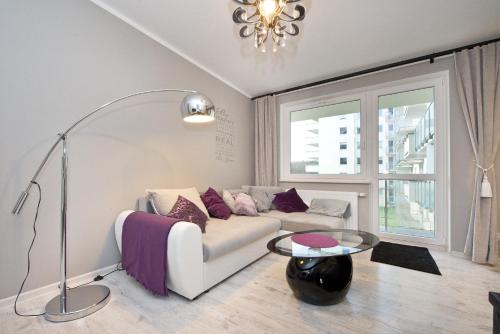 a living room with a white couch and a table at YOURAPART Gdansk Morena in Gdańsk