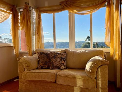 kanapę siedzącą przed dużym oknem w obiekcie Bela Vista Gramado w mieście Gramado