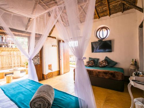 a bedroom with a canopy bed and a mirror at Hotel Boutique Venturi in Barichara