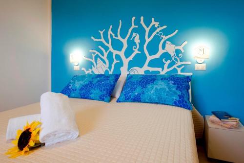 1 dormitorio con 1 cama con un mural en la pared en Hotel Maremma Sul Mare, en Montalto di Castro
