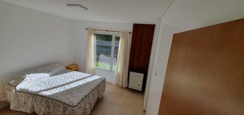 um pequeno quarto com uma cama e uma janela em cabañas arroyo de las piedras em El Calafate