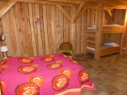 Una habitación con una manta rosa en una cama en Gîte Vernusse, 3 pièces, 6 personnes - FR-1-489-357, en Vernusse