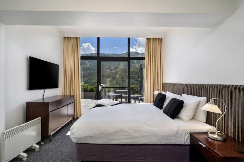 a bedroom with a large bed and a large window at Lantern 3 Bedroom Terrace with majestic mountain view in Thredbo