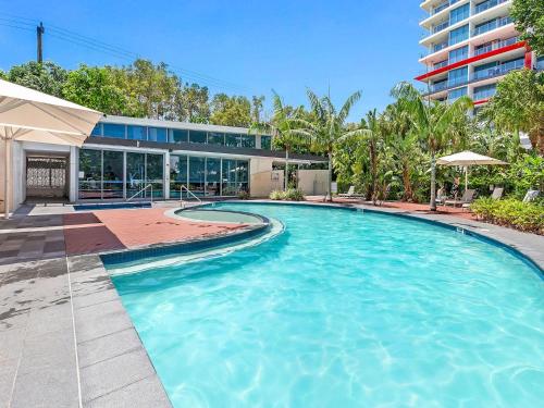a large swimming pool in front of a building at Harbour Quays Apartments in Gold Coast