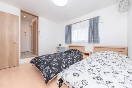 una camera da letto con un letto con un piumone bianco e nero di 合綠の宿 203 ad Osaka