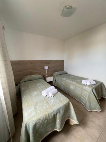 2 camas en una habitación de hotel con toallas en Chic Apartment Patria en Córdoba