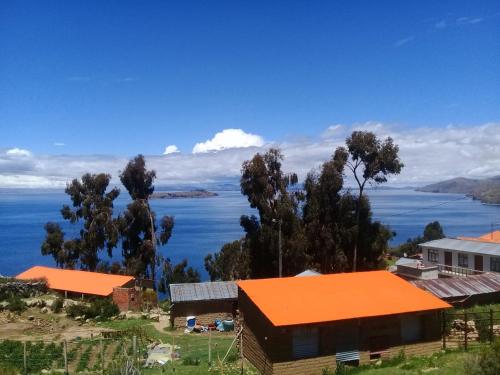 an orange roofed building with a view of a body of water at Quilla Wasi - ISLA DEL SOL in Comunidad Yumani