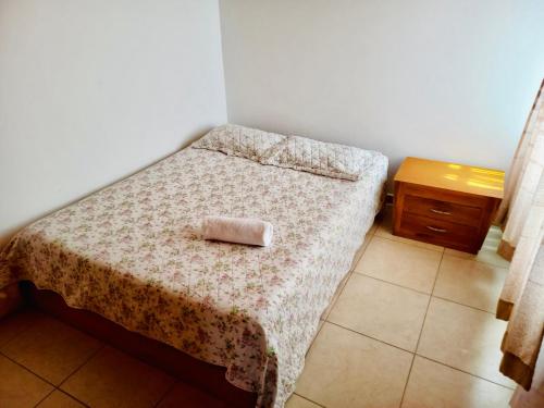 een kleine slaapkamer met een bed en een houten tafel bij Casa completa amoblada Paipa con tres alcobas in Paipa