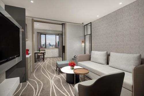 a living room with a couch and a tv at Crowne Plaza Shanghai Nanjing Road by IHG in Shanghai