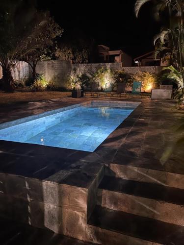 una piscina en un patio por la noche en Rez-de-chaussée indépendant avec piscine en Sainte-Marie