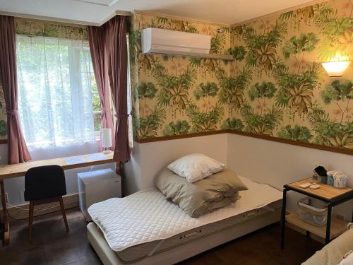 a small room with a bed and a window at Klingelbaer in Hakone