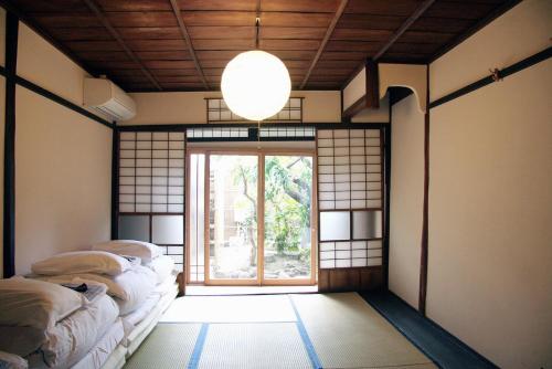 a room with four beds in a room with a window at 古都庵 Japanese Town house in Kyoto