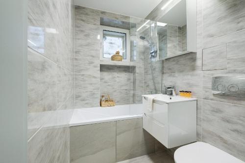 a white bathroom with a sink and a toilet at Plater Residence Apartments in Warsaw
