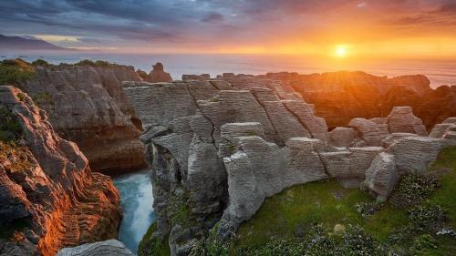 a view of a canyon with the sun setting over the ocean at Beaconstone - off grid retreat in Charleston