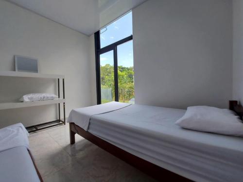 - une chambre blanche avec un lit et une fenêtre dans l'établissement Emuná Campestre, à Carmen de Apicalá