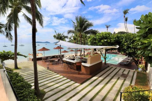 a resort with a pool and a table and chairs at Bandara Pool Villas, Phuket in Panwa Beach