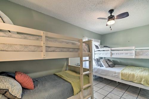 Una habitación con dos literas y un ventilador de techo. en Gulf Shores Condo with Pool and Grill Walk to Beach!, en Gulf Shores