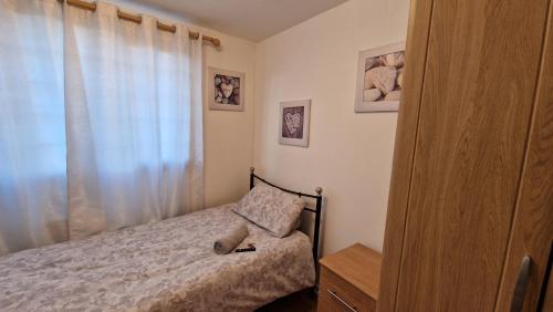 a small bedroom with a bed and a window at Shergold House in Swindon