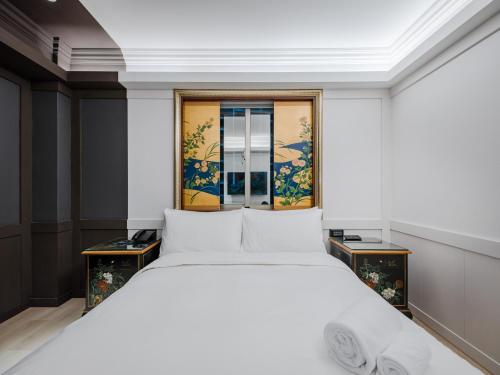 a bedroom with a white bed and a window at Archess Hotel in Taipei