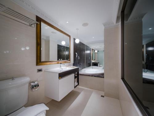 a bathroom with a toilet and a sink and a tub at Archess Hotel in Taipei