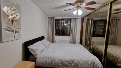 a bedroom with a bed and a ceiling fan at Shergold House in Swindon