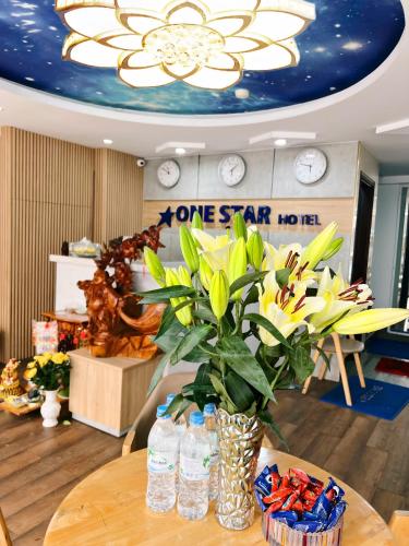 a vase with a plant on a table with water bottles at Onestar Danang Riverside in Da Nang