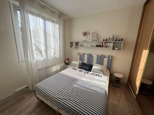 uma cama num quarto com uma grande janela em Appartement Valras-Plage, 2 pièces, 4 personnes - FR-1-701-55 em Valras-Plage