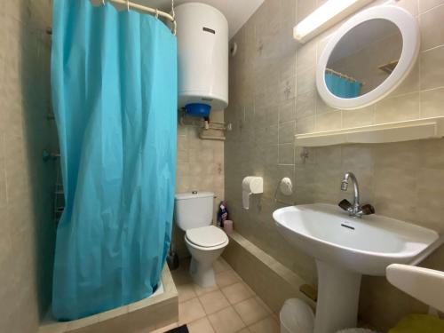 La salle de bains est pourvue d'un rideau de douche bleu et d'un lavabo. dans l'établissement Studio cabine avec balcon, piscine et parking - Sainte Maxime - FR-1-226-509, à Sainte-Maxime