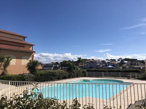 une piscine devant une maison dans l'établissement Duplex cosy avec piscine et parking à Capbreton - FR-1-239-870, à Capbreton