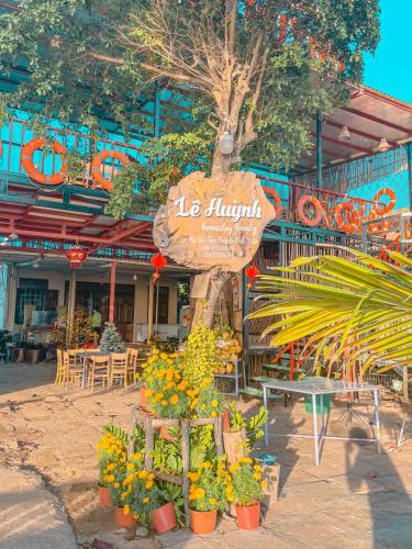 a sign for a restaurant with flowers in front of it at Lê Huỳnh Guest House Family in Ke Ga
