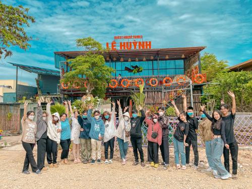 a group of people standing in front of a building at Lê Huỳnh Guest House Family in Ke Ga