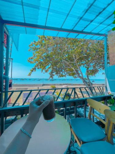 a person sitting at a table with a drink at Lê Huỳnh Guest House Family in Ke Ga