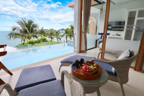 a living room with a table with a bowl of fruit on it at Bandara Pool Villas, Phuket in Panwa Beach