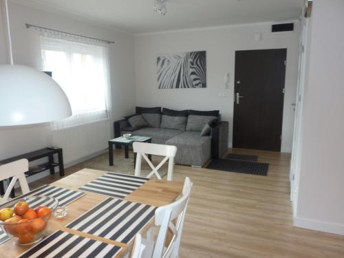 ein Wohnzimmer mit einem Tisch und einem Sofa in der Unterkunft Apartament Zebra in Świeradów-Zdrój