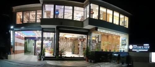 达兰萨拉Hotel Nature's View的夜晚的建筑物店面
