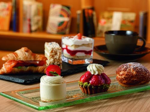 a table topped with cakes and pastries and a plate of cupcakes at Portom International Hokkaido in Chitose