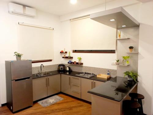 cocina con fregadero y nevera en NINETY-NINE APARTMENTS, en Kurunegala