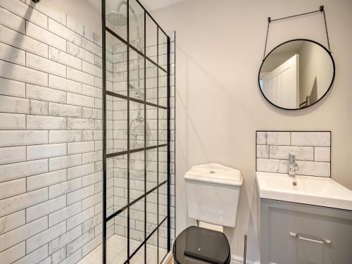 a bathroom with a toilet and a sink and a mirror at Beaches in Overstrand