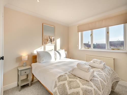 a bedroom with a large white bed with towels on it at Beaches in Overstrand