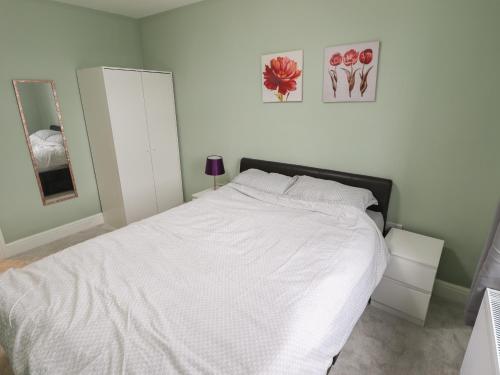 a white bedroom with a large bed with white sheets at Gordona in Mablethorpe