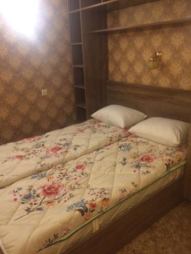 un letto con un piumone floreale e due cuscini di DILIJAN Apartment a Dilijan