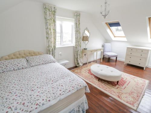 ein Schlafzimmer mit einem Bett, einem Tisch und einem Stuhl in der Unterkunft Springwood Cottage in Louisburgh