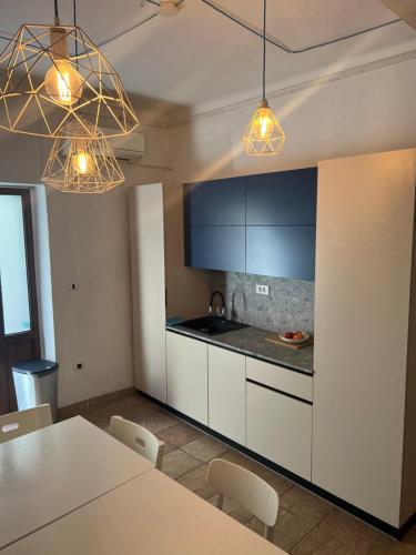 a kitchen with white cabinets and a table with chairs at OLD COURT KOPER in Koper